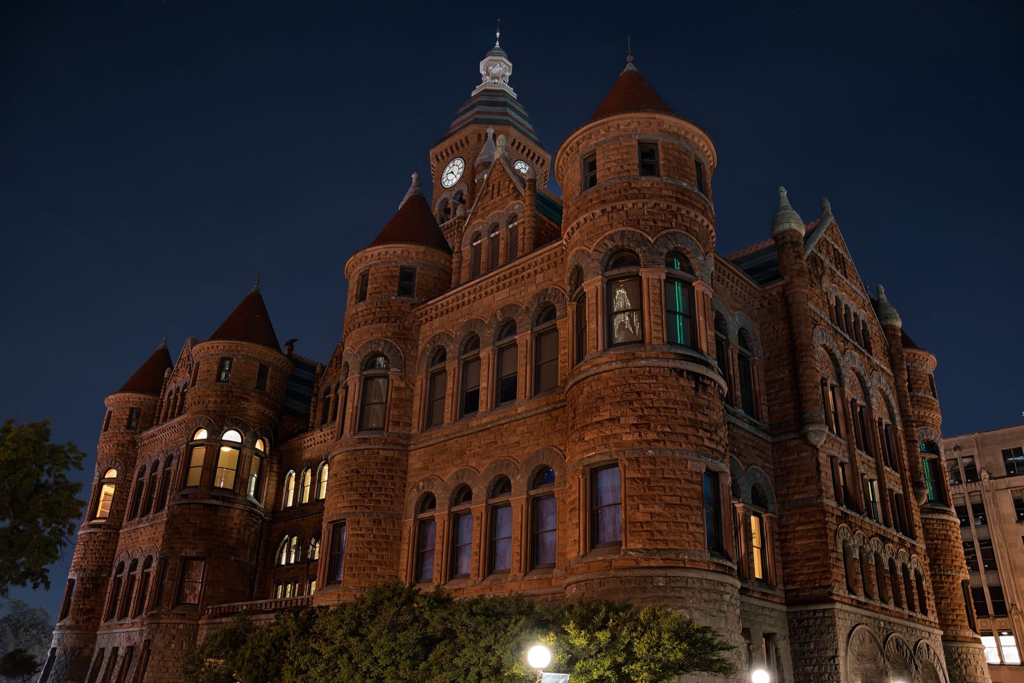 The red sandstone Old Red Courthouse in downtown Dallas lit up at night.