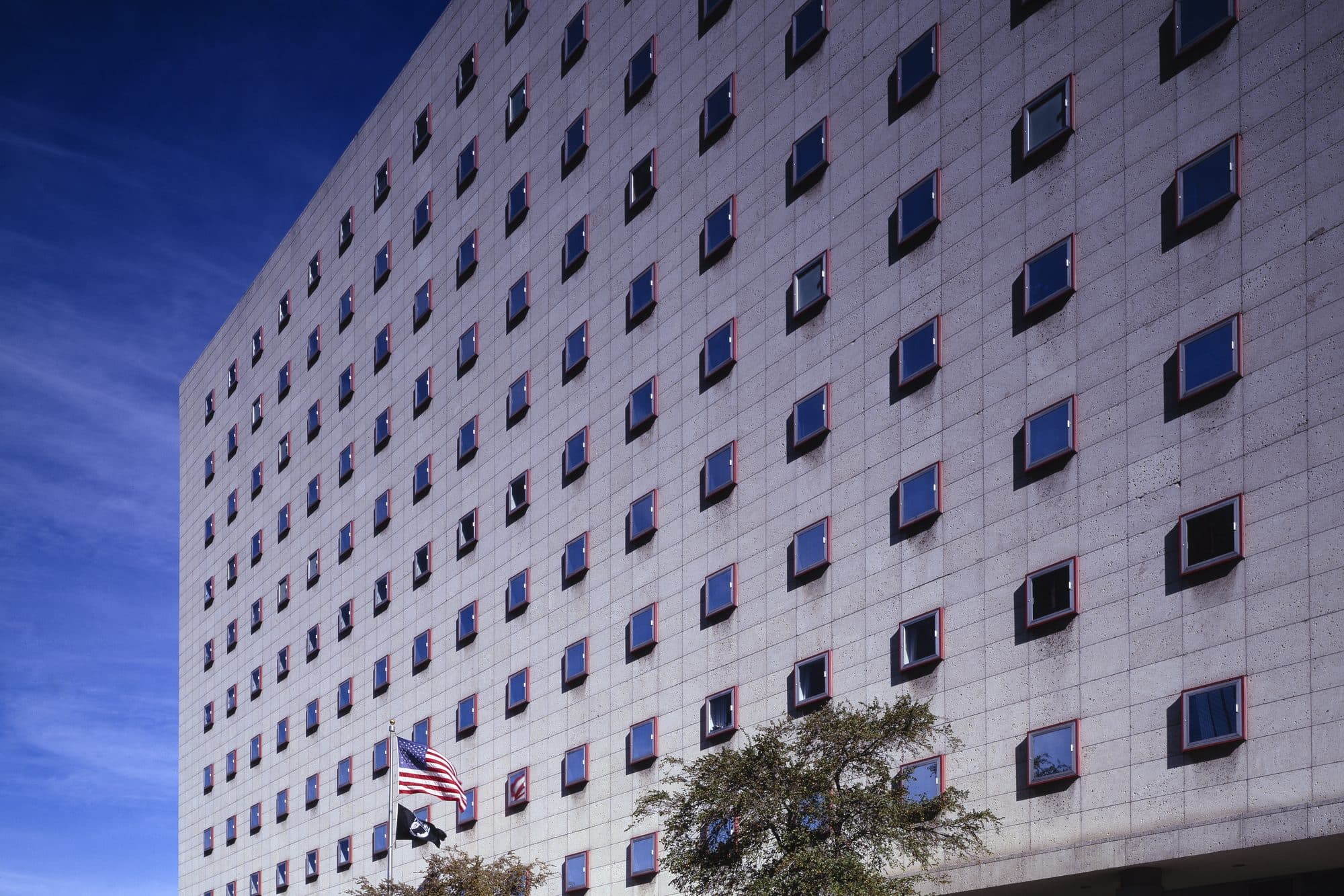 A tall federal courthouse in Houston with an American flag flying in front.