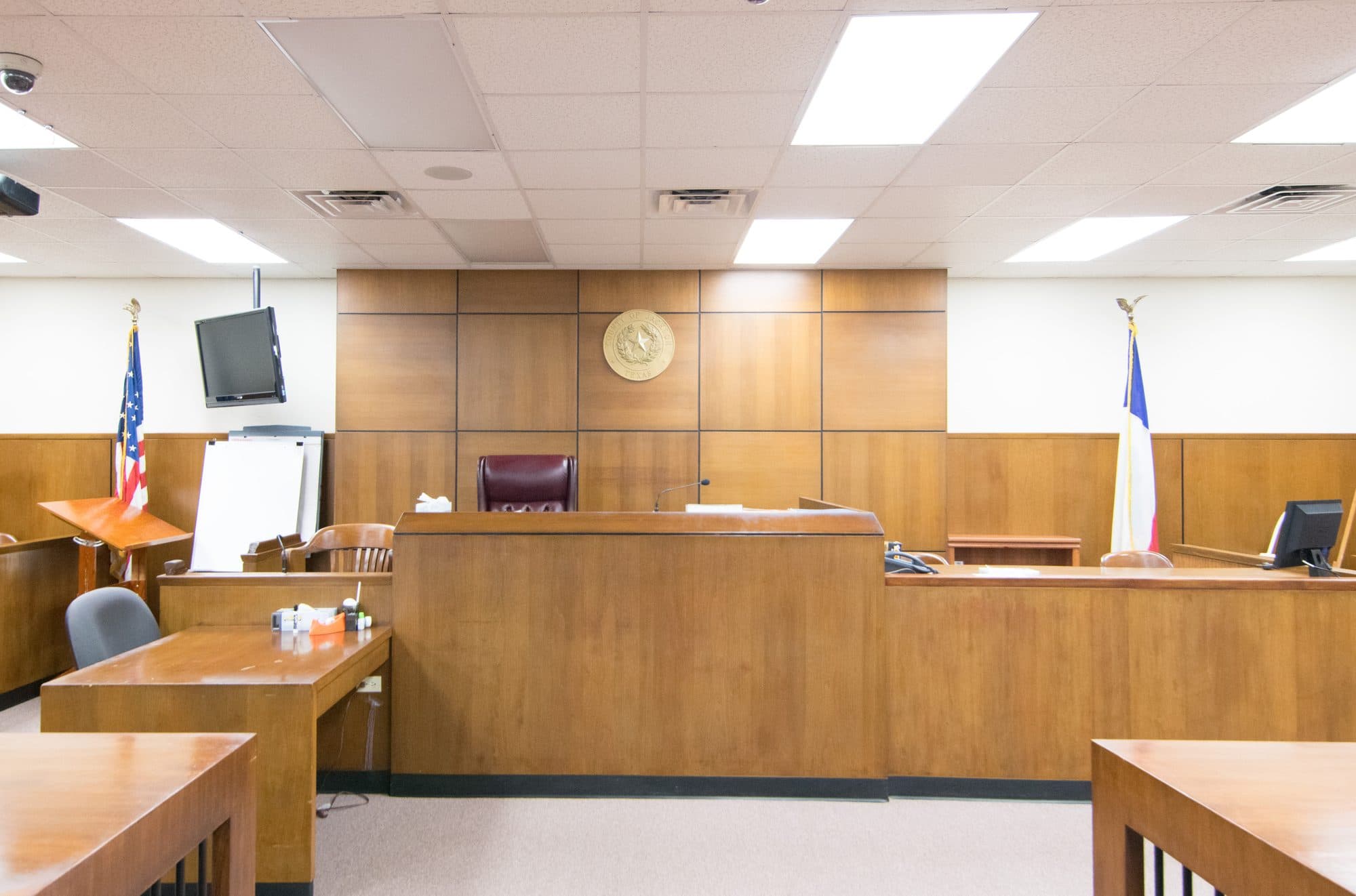 The judge's bench in a county courtroom in Edna, Texas, with American and Texas flags.